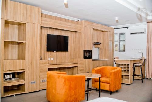 Habitación con TV, mesa y sillas. en 1401 Luxury Apartment en Uyo