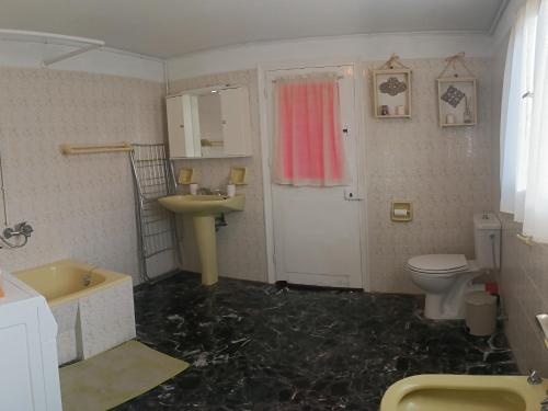 La salle de bains est pourvue d'un sol en marbre noir, de toilettes et d'un lavabo. dans l'établissement Το σπιτάκι στον παραδοσιακό οικισμό Λειβαδίων Άνδρου, à Vrakhnós