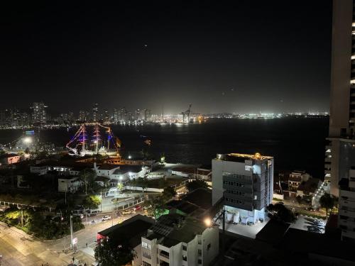 Una ciudad de noche con una noria en la distancia en Apartamentos En Edificio Portofino ICDI en Cartagena de Indias
