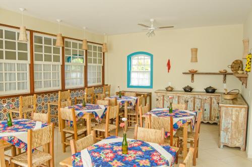 een eetkamer met tafels en stoelen en een plafondventilator bij Pousada Pomar Paraty in Paraty
