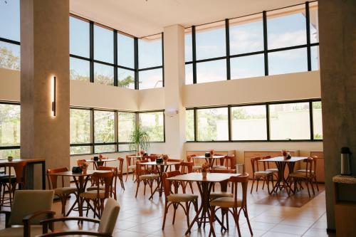 a restaurant with tables and chairs and windows at SLZ Lagoa Hotel in São Luís