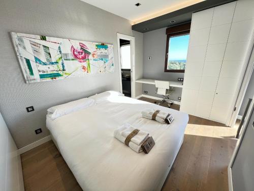 sypialnia z dużym białym łóżkiem i 2 ręcznikami w obiekcie PUSHE Playa Granada Beach & Golf 24 w mieście Motril