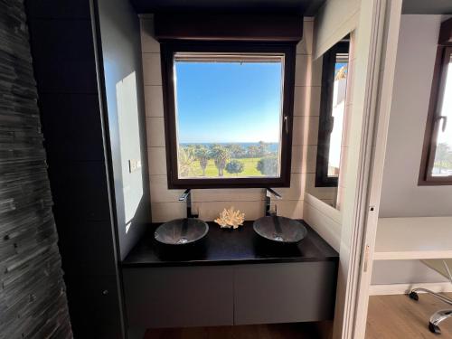 łazienka z 3 umywalkami i dużym oknem w obiekcie PUSHE Playa Granada Beach & Golf 24 w mieście Motril