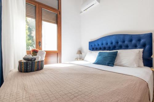 a bedroom with a large bed with a blue headboard at mascot traditional guest house in Rhodes Town