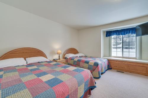 una camera da letto con due letti e una finestra di Cozy Mancelona Home Ski, Golf and Snowmobile! a Mancelona