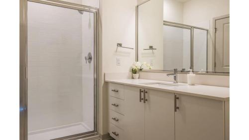 a bathroom with two sinks and a glass shower at Stunning Nulu 1BR CozySuites 04 in Louisville