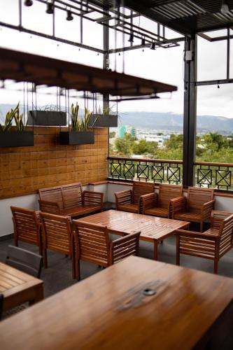 a restaurant with wooden tables and chairs with a view at The Lu'um House in Tuxtla Gutiérrez