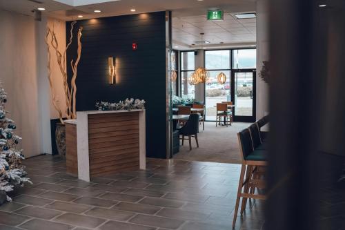 a lobby with a restaurant with a christmas tree on the wall at Four Points by Sheraton Penticton at the Convention Centre in Penticton