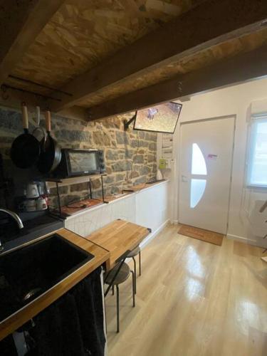 - une cuisine avec une table en bois et un comptoir dans l'établissement Studio charmant et cosy, à Saint-Brieuc