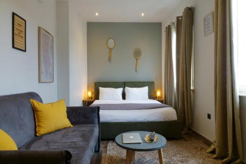 a hotel room with a bed and a couch at The Athens Version Luxury Suites in Athens