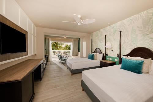 een hotelkamer met 2 bedden en een flatscreen-tv bij Bahia Principe Grand Jamaica - All Inclusive in Runaway Bay