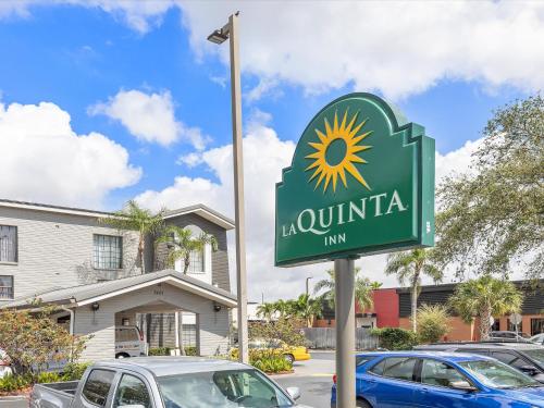 a sign for aulum inn in a parking lot at La Quinta Inn by Wyndham Miami Airport North in Miami