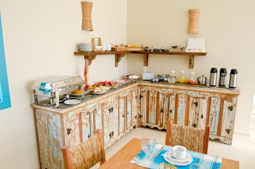 a kitchen with wooden cabinets and a table at Quinta Brasilis Boutique Hotel Paraty in Paraty