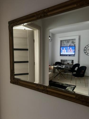 Apartament Nowar في نوا رودا: مرآة معلقة على جدار مع غرفة معيشة