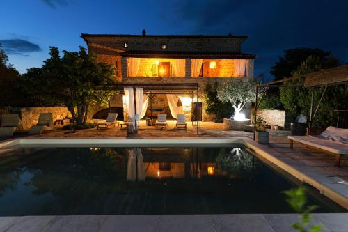 une maison avec piscine la nuit dans l'établissement La Gourmandine, à Courry