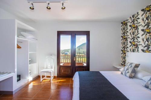 Habitación blanca con cama y balcón. en Villa Barrilla - La Vegueta Villas, en Tinajo