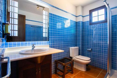 ein blau gefliestes Badezimmer mit Toilette und Waschbecken in der Unterkunft Villa Barrilla - La Vegueta Villas in Tinajo
