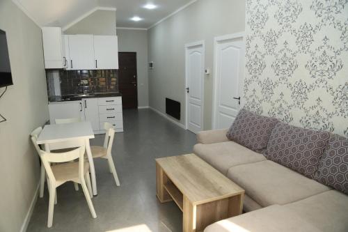 a living room with a couch and a table and a kitchen at Meghu Guest House in Aghavnavankʼ