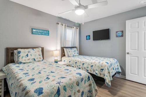 a bedroom with two beds and a flat screen tv at Plantation 4206 in Gulf Shores