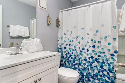 a bathroom with a toilet and a shower curtain at Plantation 4206 in Gulf Shores