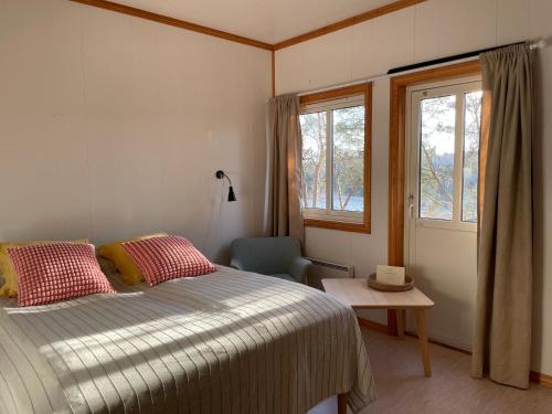 a bedroom with a bed and a chair and a window at Norsjøtunet in Akkerhaugen