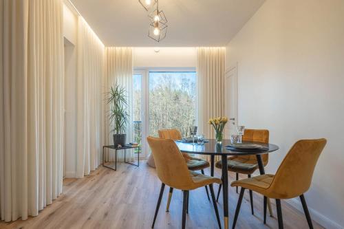 una sala da pranzo con tavolo e sedie di Melnragė II terasa a Klaipėda