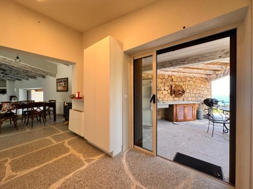 a living room with a large sliding glass door with a fireplace at Charlie Home - Heart of Sardinia in Costa Paradiso