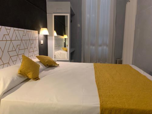 a bedroom with a large white bed with yellow pillows at Villa Giovanna Citylife Milano in Milan