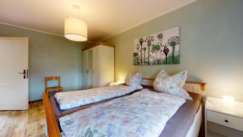 ein Schlafzimmer mit einem Bett und einem Wandgemälde in der Unterkunft Karls Ferienhaus in Großkoschen