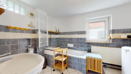 ein Badezimmer mit einer Badewanne und einem Waschbecken in der Unterkunft Karls Ferienhaus in Großkoschen