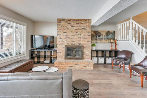 a living room with a couch and a fireplace at Riverfront Champlin Townhome with Deck and Water View! in Champlin