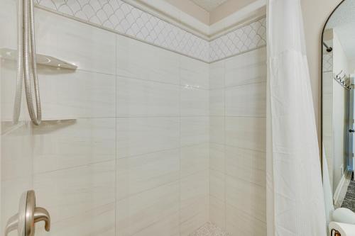 a white bathroom with a shower with a shower curtain at Riverfront Champlin Townhome with Deck and Water View! in Champlin