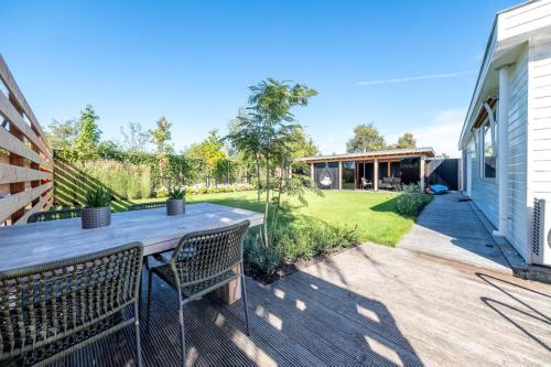 a backyard with a wooden table and chairs at New- Private Cosy Houseboat, on a lake near Amsterdam in Vinkeveen