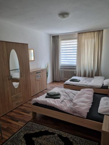 a hotel room with two beds and a mirror at Glücks Ferienwohnungen in Bremerhaven