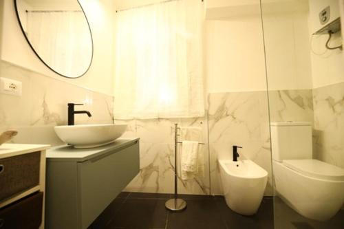 bagno bianco con lavandino e servizi igienici di Casa Nica a Palermo