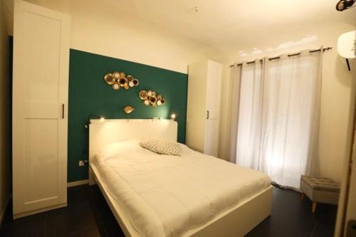 una camera con un letto bianco e una parete verde di Casa Nica a Palermo