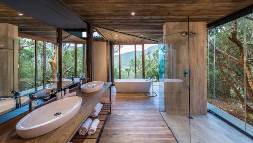 a bathroom with two sinks and a tub and a shower at Kariega Game Reserve Settlers Drift in Alexandria