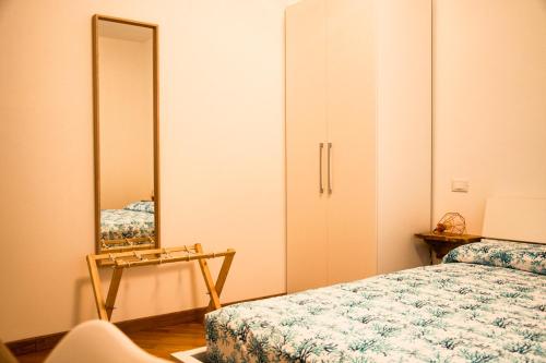 Schlafzimmer mit einem Bett und einem Spiegel in der Unterkunft Villa Essenza - Rooms and Breakfast in Albenga