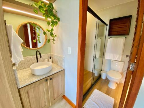 a bathroom with a sink and a toilet and a mirror at Taíba Beach Resort por Be My Guest! in São Gonçalo do Amarante