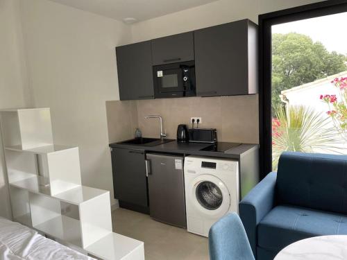 a kitchen with a washing machine in a living room at Studio familial centre ville, Parc expo, Arena in Pérols