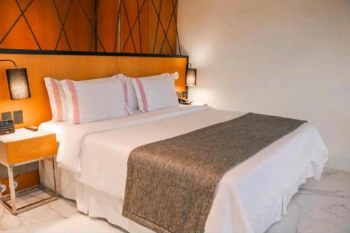 - une chambre avec un grand lit blanc et une table dans l'établissement Hotel Nacional rj, à Rio de Janeiro