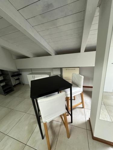 a black and white table and two chairs in a room at B&B le palme mini appartamento mansardato in Bentivoglio