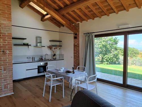 托斯卡納馬利亞諾的住宿－Casa Maria，厨房以及带桌椅的用餐室。