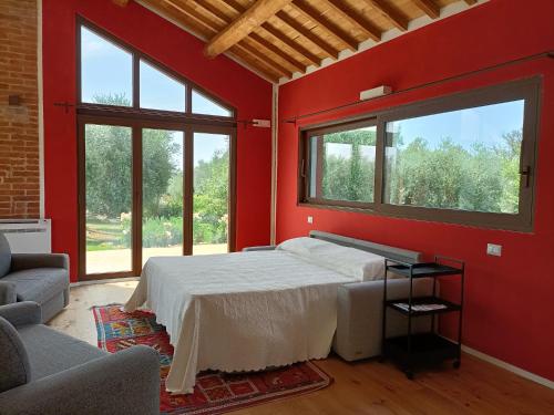 托斯卡納馬利亞諾的住宿－Casa Maria，一间设有床铺的卧室,位于一个红色墙壁的房间
