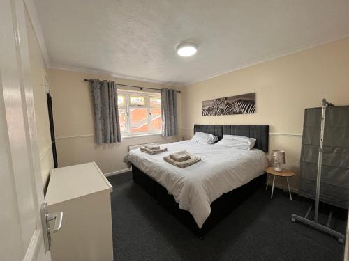 Un dormitorio con una cama grande y una ventana en Cosy 2 bedroomed semi detached house, en Brettell Lane