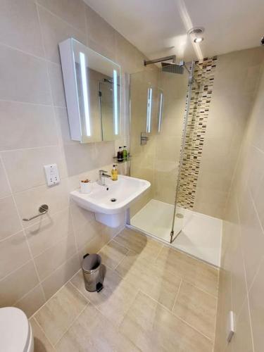 a white bathroom with a sink and a shower at Meadow View in Aysgarth