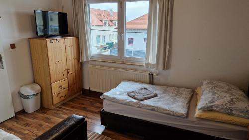 um pequeno quarto com uma cama e uma janela em Sterische Bierinsel em Strasshof an der Nordbahn