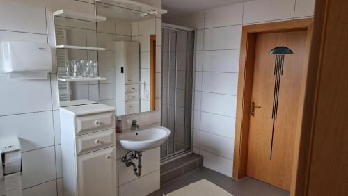 uma casa de banho branca com um lavatório e um espelho em Sterische Bierinsel em Strasshof an der Nordbahn