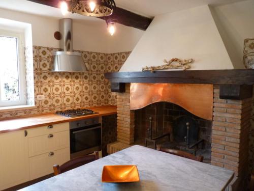 a kitchen with a stove and a brick fireplace at Casa Asia in Castiglione della Pescaia