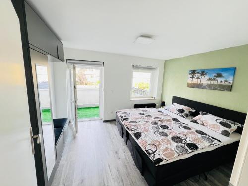 a bedroom with a bed in a room with windows at Traumhafte City-Wohnung in Mönchengladbach